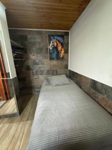 a bed in a room with a brick wall at Hospedaje Shuyen in Victoria