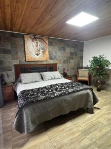 a bedroom with a large bed with a stone wall at Hospedaje Shuyen in Victoria +51 photos