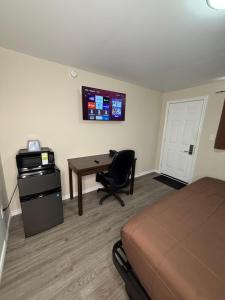 a hotel room with a bed and a desk with a computer at Falls Lodge by the Falls (Formerly Knights Inn) in Niagara Falls