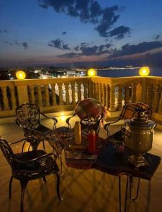 a patio with a table and chairs on a balcony at NovArt Gallery Hotel in Sumqayıt