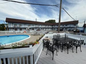 a deck with a table and chairs next to a pool at Falls Lodge by the Falls (Formerly Knights Inn) in Niagara Falls