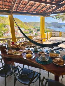 a table with food on it on a balcony at Casa Bela Vista in Piranhas