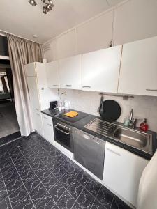 a kitchen with white cabinets and a sink at naMaaStay in Maastricht
