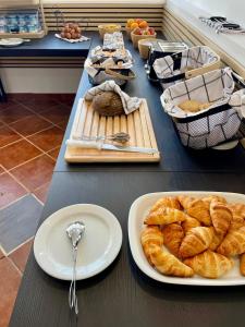 a table topped with plates of croissants and bread at Residencial do Vale in Funchal +57 photos