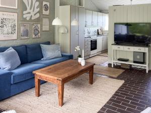 a living room with a blue couch and a coffee table at 4 person holiday home in Aabenraa in Aabenraa
