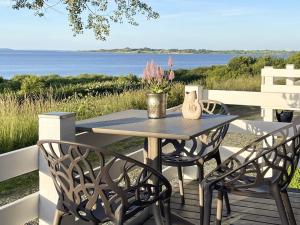 a table and chairs on a deck with a view of the water at 4 person holiday home in Aabenraa in Aabenraa