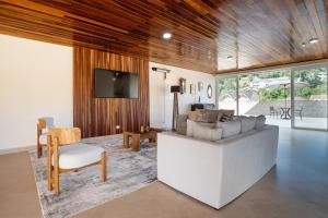 a living room with a couch and a tv at Pousada Sol da Mantiqueira in Campos do Jordão
