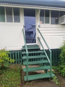 a green staircase on the front of a house at Horseshoe House - Gympie in Gympie