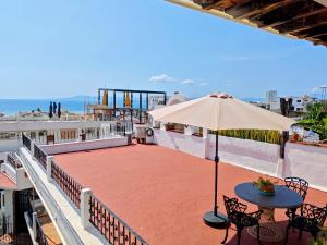 a patio with an umbrella and a table and chairs at Casa Rey Sol Vallarta in Puerto Vallarta
