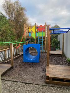 a playground with a slide and a play structure at Arthurstown Rd Riverview House in Ruatapu