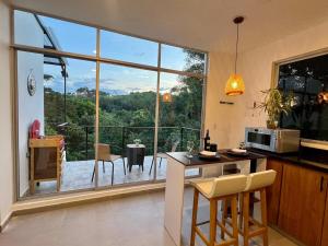 a kitchen with a large window with a view of a balcony at Finca Samana in Tocaima