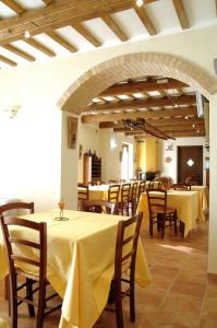 Loro PicenoにあるVilla le Vigneのテーブルと椅子(黄色のテーブルクロス付)が備わるレストラン