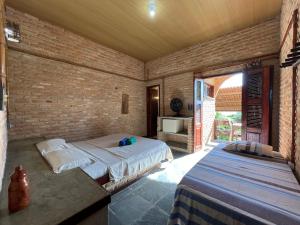 a bedroom with two beds and a brick wall at Pousada Sol Nascente in Beberibe +231 photos