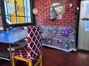 a table and a couch in a room with a brick wall at Hostel Viajeros Arequipa in Arequipa