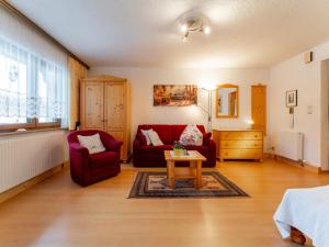 a living room with a red couch and a table at Maria in Leogang