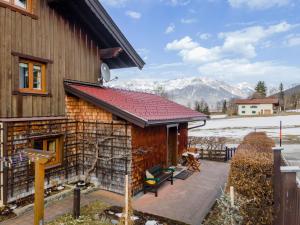 a house with a red roof with mountains in the background at Maria in Leogang