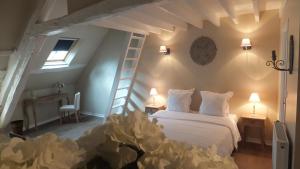 a bedroom with a white bed and a ladder at Hotel La Closeraie in Sully-sur-Loire