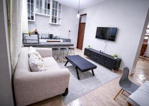 a living room with a couch and a kitchen at Rosewood Cozy homes in Mbeya