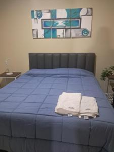a blue bed with two towels on top of it at Donde topa in Las Heras