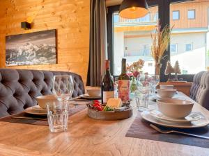 a wooden table with wine bottles and glasses on it at Rattendorf 5B in Rattendorf