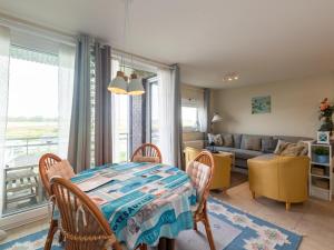a living room with a table and chairs and a couch at Nieuwendamme 40C in Lombardsijde