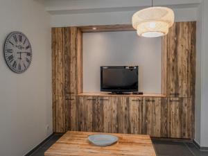 a room with a tv and a table and a clock at Lac Bleu nr 19 in Lacapelle-Marival