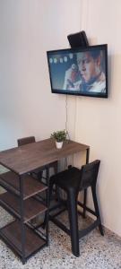 a table and chair with a tv on the wall at Apartamento C&B in Bello