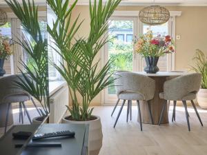 a dining room with a table and chairs and plants at t Kaatsheuveltje 9 in Kaatsheuvel
