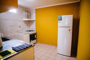 a kitchen with a white refrigerator and a yellow wall at Donde topa in Las Heras +9 photos