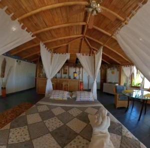 a bedroom with a bed and a checkerboard floor at Bora Bora Bungalows in Los Órganos +137 photos