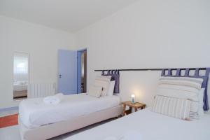 two white beds in a room with a room with a bedsenalsenal at Feel Nazaré - Ocean Villa in Nazaré +36 photos