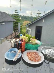 a table with plates of food on a patio at บ้านพัก เย็นเย็นแคมป์ปิ้ง อิน เขาค้อ in Ban Pa Daeng
