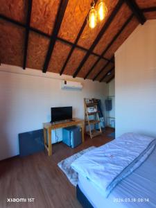 a bedroom with a bed and a desk with a computer at บ้านพัก เย็นเย็นแคมป์ปิ้ง อิน เขาค้อ in Ban Pa Daeng