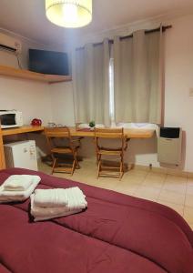a room with a bed and a kitchen with a table at Patio Prana Apart Resto in Federación