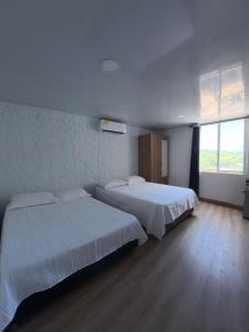 a bedroom with two beds and a large window at Apartamentos Isla Tropical in San Andrés +156 photos