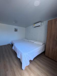 a bedroom with a bed with a white bedspread at Apartamentos Isla Tropical in San Andrés