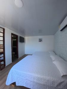 a white bedroom with a white bed in it at Apartamentos Isla Tropical in San Andrés