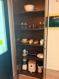 a cupboard with plates and bowls and dishes in it at Sweet House 3 in Arrecife