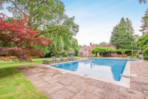 a swimming pool in a yard with chairs and a house at 6 Bed in Haslemere oc-c34083 in Haslemere
