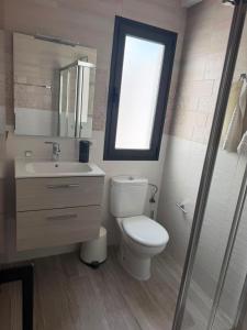a bathroom with a toilet and a sink and a window at Sweet House 3 in Arrecife +3 photos