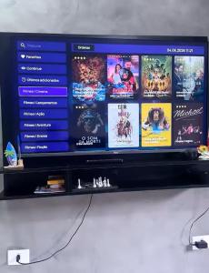 a television screen with many movies on it at Sobrados Novos Litoral Norte Caraguatatuba, a 150 m a pe da Praia das Palmeiras, Ar condicionado, WiFi gratis, Churrasqueira privativa, Pet friendly, Estacionamento in Caraguatatuba