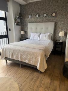 a bedroom with a large bed and two clocks on the wall at EON One Bedroom Apartment 1305 in Estación Pamplona +20 photos