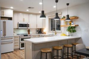 a kitchen with white cabinets and a island with bar stools at Citrus Grove in Mesa
