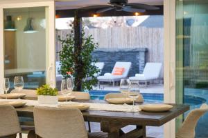 a wooden table with chairs and wine glasses on a patio at Citrus Grove in Mesa +71 photos