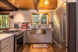 a kitchen with white cabinets and a stainless steel refrigerator at On Mountain Time in Glacier