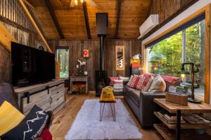 a living room with a couch and a tv at On Mountain Time in Glacier
