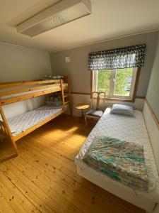 a bedroom with two bunk beds and a window at Norrfällsvikens Vandrarhem in Mjällom