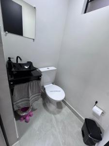 a bathroom with a white toilet and a sink at Sobrados Novos Litoral Norte Caraguatatuba, a 150 m a pe da Praia das Palmeiras, Ar condicionado, WiFi gratis, Churrasqueira privativa, Pet friendly, Estacionamento in Caraguatatuba +40 photos