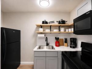 a kitchen with a sink and a black refrigerator at KC's Corner Motel in East Springfield