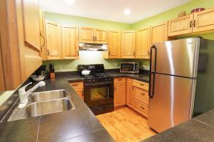 a kitchen with wooden cabinets and a stainless steel refrigerator at Glacier Pines in Glacier